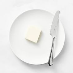 a piece of butter on a plate with a knife and fork