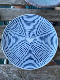 a blue and white plate sitting on top of a wooden table next to a bowl