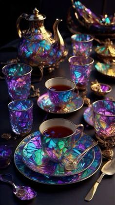 a table topped with lots of purple and blue glass dishes filled with teacups