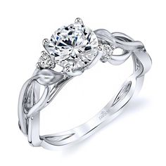 a white gold engagement ring with an oval center stone and leaves on the band, set in