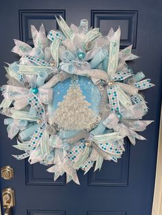 a blue and white christmas wreath on the front door