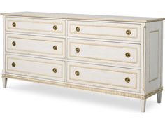 a white dresser with gold trimmings on the top and bottom drawers, against a white background