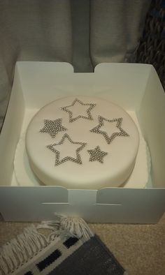 a white cake with silver stars in a box