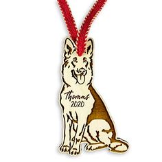 a wooden ornament with a german shepard dog on it's side and a red ribbon around its neck