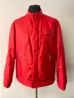 Men's Vintage ski jacket circa 1970/1980 made by Toper sportswear. Tailored by McGregor. Red ski jacket.  High Chinese collar with ribbed inside and hidden hood. Hidden zipper closure that opens on both ends and additional snap closure.  Zipped hip pockets with a fleece lining. Inside pocket with zipper. The jacket has ribbed side panels and ribbed cuffs. The waistband has stitched detailing.  Toper was the official supplier of skiwear for the Yugoslavian representative ski teams. Good condition 80s Ski Jacket, Red Ski Jacket, Vintage Ski Jacket, Ski Vintage, Hidden Hood, Chinese Collar, Sides For Ribs, Ski Jacket Mens, Vintage Ski