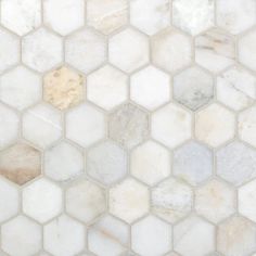 white marble hexagonal tiles with brown and beige accents on the backsplash