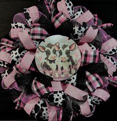 a pink and black wreath with cow faces on it