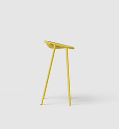 a small yellow stool sitting on top of a white floor