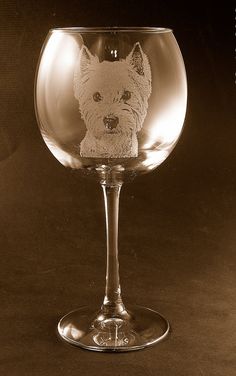 a wine glass with a small dog drawn on the side in it's center