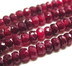 red glass beads are lined up on a white surface