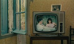 an old tv sitting on top of a wooden table