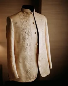 a white jacket is sitting on a mannequin's head and has a lamp next to it