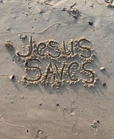 the word jesus saves written in sand on a beach