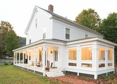 a large white house sitting on top of a lush green field