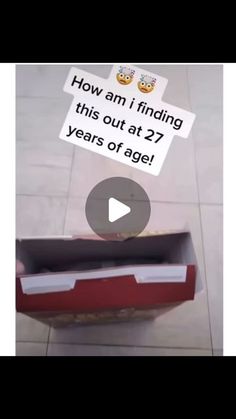 an open red box sitting on top of a tile floor next to a sign that says how am i finding this out at 27 years of age