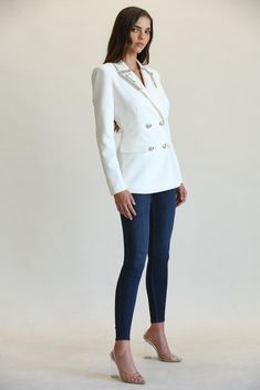 This blazer is not your average blazer. Cut from a solid woven stretch fabric for suiting, the blazer has rhinestone beaded embellishments along the trim of the lapel collar and silver buttons for a front closure. "Dazzle Me White Blazer Jacket" Full lined Princess seams Double breasted Polyester/Spandex Dry clean Imported