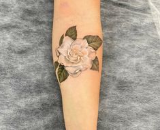 a woman's arm with a rose tattoo on it