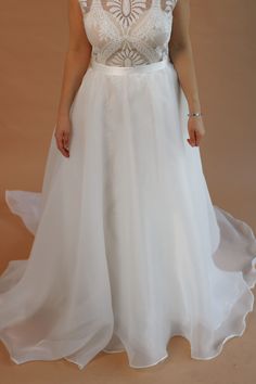 a woman in a white wedding dress posing for the camera with her hands on her hips