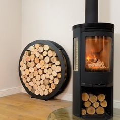 a wood burning stove next to a stack of logs