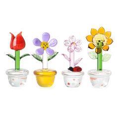 four glass flower vases with flowers in them