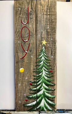 two wooden boards with christmas trees painted on them and the words joy written in red