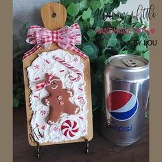 a gingerbread cookie is next to a can of pepsi and a christmas ornament