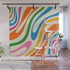 a colorful wall mural in the living room with a ladder and potted plant next to it