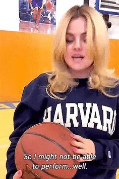 a woman holding a basketball in front of her face with the words harvard written on it