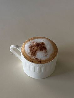 a cappuccino with cinnamon sprinkles in a white cup