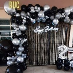 black and silver balloons in front of a happy birthday sign with the number twenty two