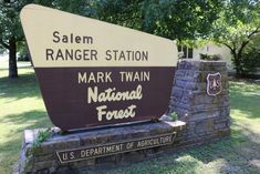 a large sign in front of a stone and brick wall that says, salem ranger station mark twain national forest