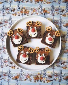 there are four pieces of brownies with reindeer faces on them sitting on a white plate