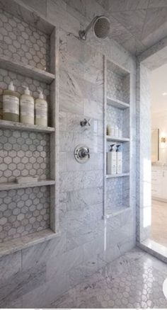 a large bathroom with marble walls and shelves