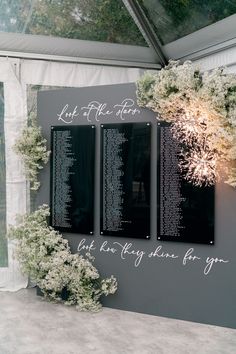 three black and white photographs on a wall with flowers in the corner, next to each other