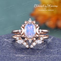 a ring with an opal stone surrounded by diamonds on top of a blue rock