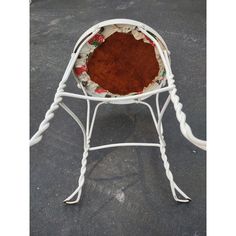 a white iron chair with a wooden seat