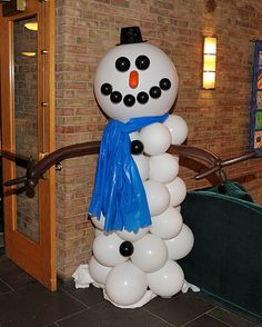 a snowman made out of balloons in front of a brick wall