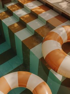 two inflatable swimming rings sitting on the ground next to each other near a tiled floor