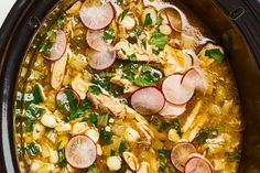 a crock pot filled with chicken and radishes