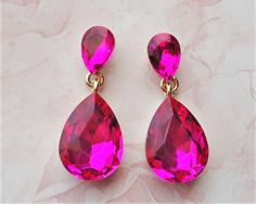 Elegant, opulent, and shimmery  This brilliant classic earrings features hot pink Swarovski crystals. Crystals are set on a secure prong settings, made of brass and plated in 18 karat gold. These earrings have surgical steel posts and measure 1.25" in length. Earrings are light weight and sway gracefully as you move about your day. These stunning dangle earrings are unique, feminine and eye-catching, Perfect for a bride that wants to make a statement or anyone to wear to a special occasion! Pink Jewelry For Valentine's Evening, Pink Drop Crystal Earrings For Party, Pink Teardrop Bridal Earrings For Party, Pink Drop Earrings For Party, Pink Drop Crystal Earrings For Wedding, Pink Sparkling Stones Crystal Earrings For Wedding, Pink Crystal Earrings With Sparkling Stones For Wedding, Pink Crystal Bridal Earrings For Party, Pink Crystal Earrings For Formal Occasions