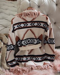 A stunning knit blanket sweater that is perfectly cozy for the season. Open front & soft fringe fold over collar. Color: Cream, camel & black Poly Hand wash cold Model is a size 8 wearing a medium. Small Medium Large Bust 50 52 53 Waist 49 51 52 Hips 51 53 54 Length 31 31 31 Bust, waist, and hip measurements are a total circumference. Length is measured from the top of the shirt to the hem. Measurements are an estimate. Beige Shawl Collar Sweater Coat For Fall, Bohemian Brown Sweater Coat For Fall, Chic Shawl Collar Sweater For Fall, Beige Long Sleeve Sweater With Fringe, Camel Long Sleeve Sweater For Fall, Long Sleeve Camel Sweater For Fall, Knit Outerwear With Fringe For Fall, Knit Fringe Outerwear For Fall, Beige Shawl Collar Sweater For Fall