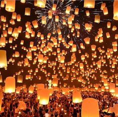 many people are flying lanterns in the sky