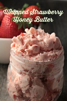 whipped strawberry honey butter in a jar with strawberries behind it and the words, whipped strawberry honey butter