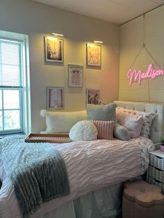 a bed room with a neatly made bed and pictures on the wall above it's headboard