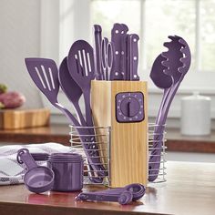 purple kitchen utensils are sitting in a basket