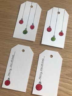 four tags with christmas ornaments hanging from them