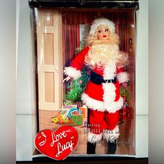 a santa clause doll in a box with a red heart on the bottom and an i love lucy sign above it