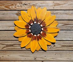 a yellow flower sitting on top of a wooden floor