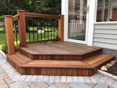 a wooden deck with steps leading up to the front door