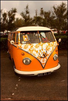 an orange and white vw bus parked in a parking lot